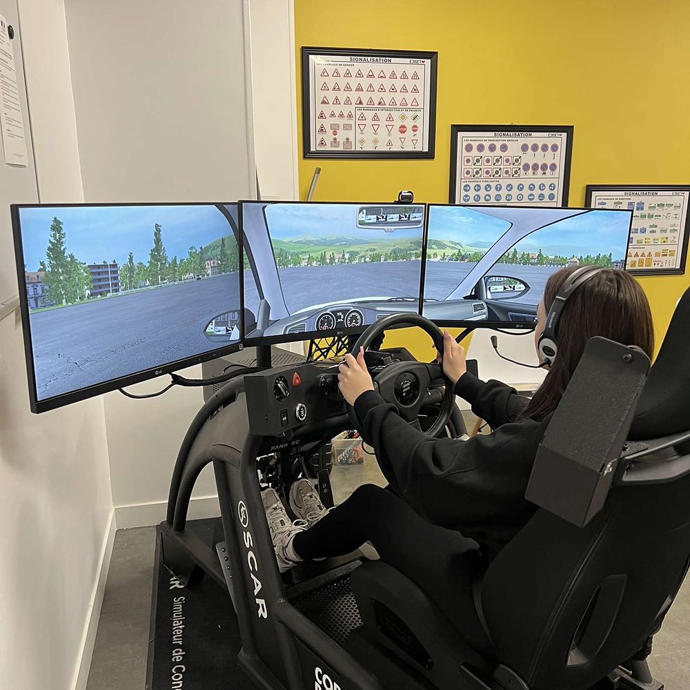 Une élève au simulateur de conduite à trois écrans